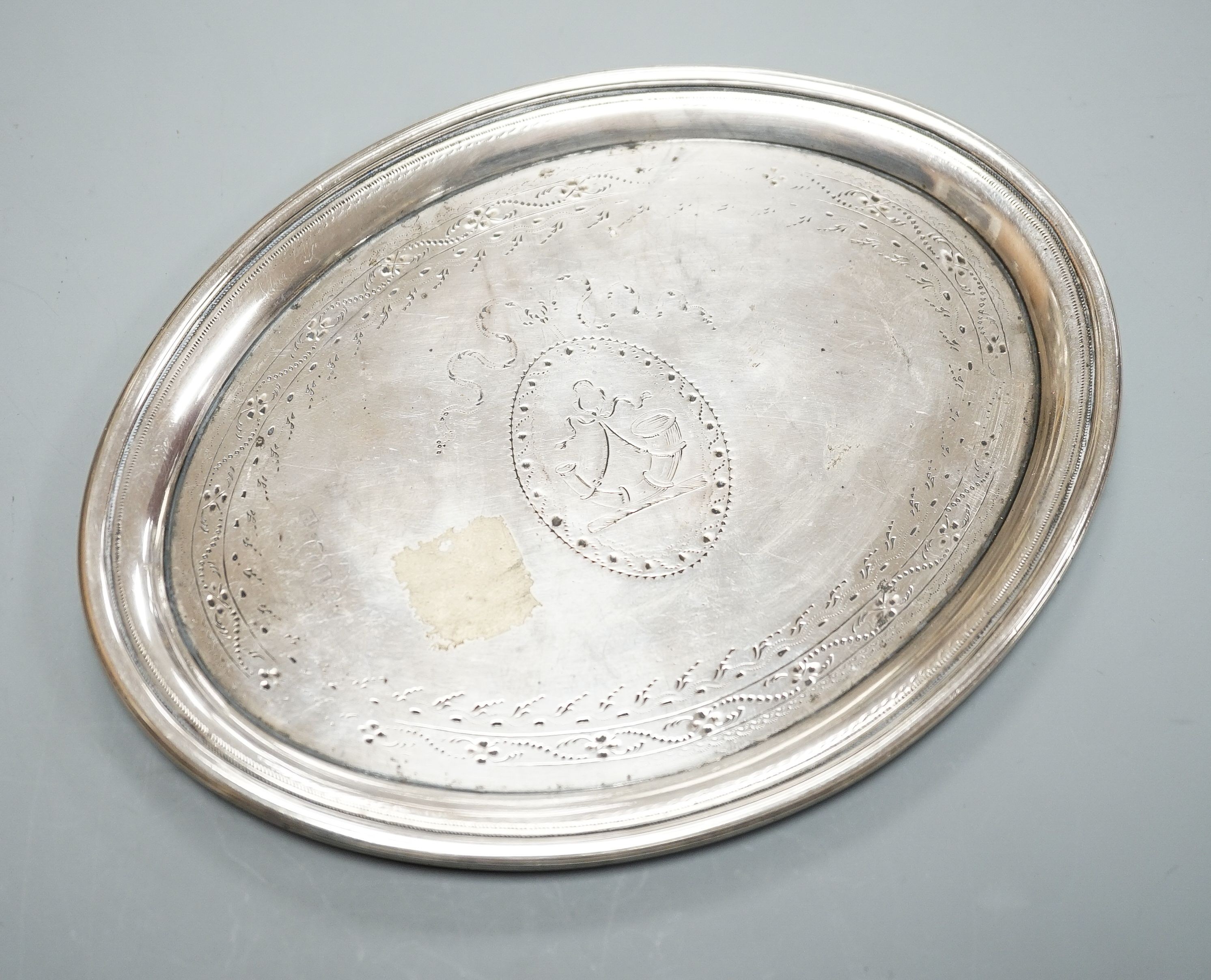 A George III silver oval teapot stand, with tired engraved decoration and wooden base, London, 1790, marks quite rubbed, 16.9cm.